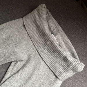 Grå stickade byxor från Gina tricot  - Mysiga grå stickade byxor från Glamorous med bred ribbad midja och bootcut ben. Perfekta för en avslappnad stil och supermjuka mot huden. Enkel design som passar till många olika toppar.