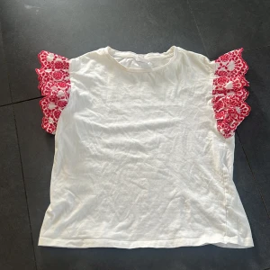 Vit topp från Zara - Säljer en vit topp från Zara med korta volangärmar i vitt och rött. Inga defekter, skriv vid frågor ❤️