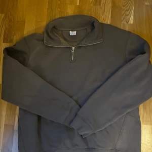 Zara zip tröja  - Mysig Oliv tröja från ZARA med halv dragkedja framtill och hög krage. Perfekt för kyliga sommarkvällar och enkel att dra på sig. Tröjan har långa ärmar och ett mjukt, värmande foder på insidan.