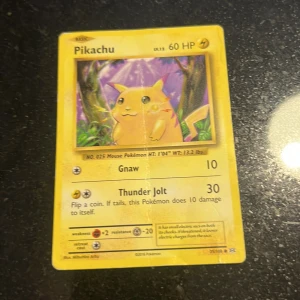 Pikachu - Detta är ett samlarkort från Pokémon med Pikachu, en av de mest ikoniska figurerna. Perfekt för dig som gillar spel, samlarobjekt och nostalgi! Kortet har färgglad design och är en klassiker bland Pokémon-fans.