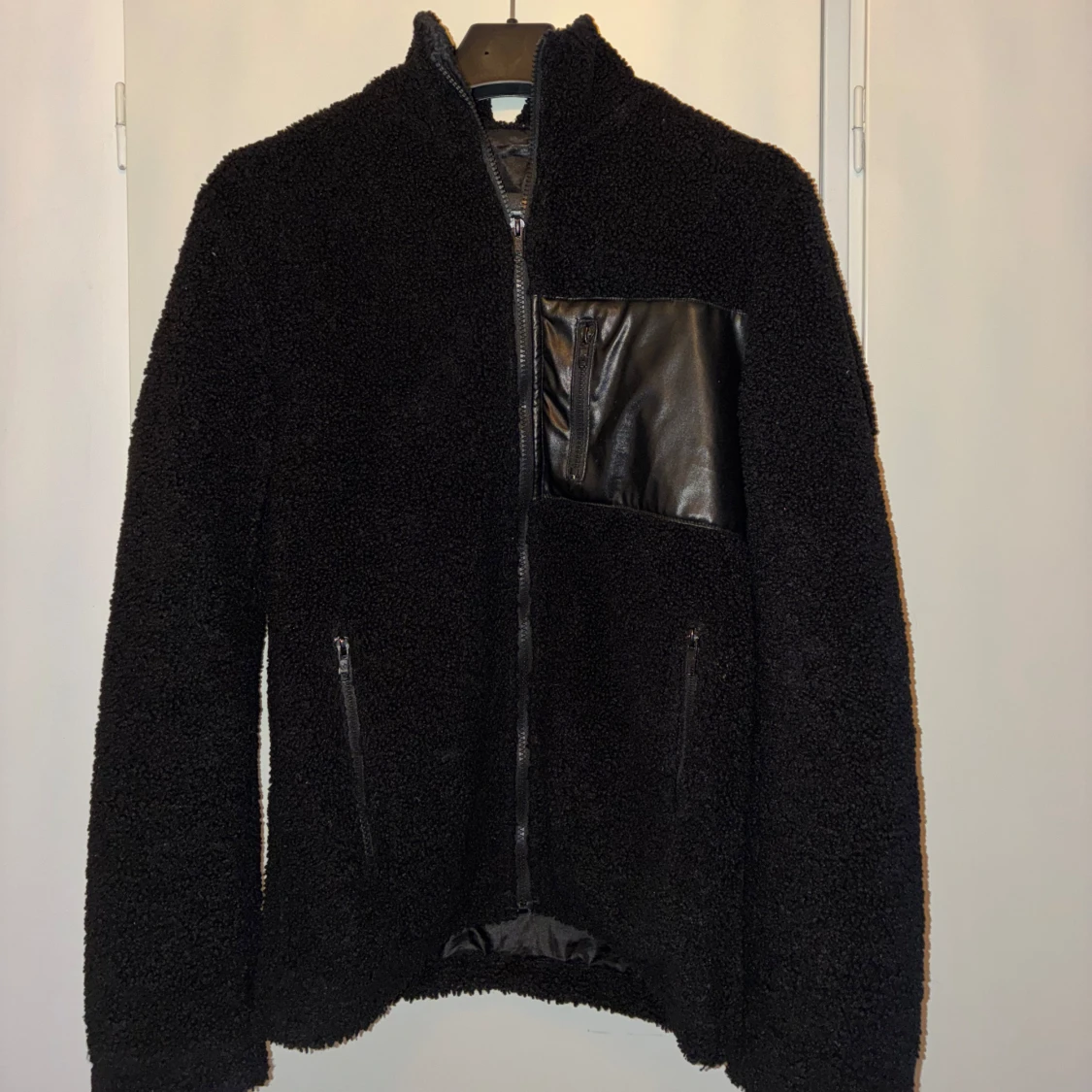 Svart teddyjacka med ficka i skinn