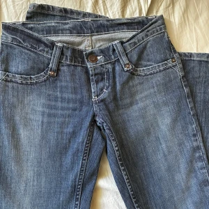 blåa jeans 💞 - As snygga vintage blåjeans med väldigt low rise. 100% bomull med unika detaljer på bakfickorna med vit stitch! Tidigare köpt på vinted men säljer eftersom de ej passar mig🥹 skriv vid frågor!💕