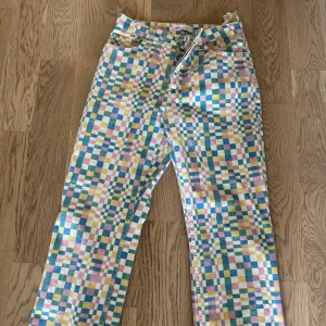Färgglada rutiga jeans från Zara - Unika jeans från Zara med färgglatt rutigt mönster i blått, rosa, gult och vitt. Modellen har raka ben och klassisk femficksdesign. Perfekta för dig som vill sticka ut med en lekfull och trendig look.