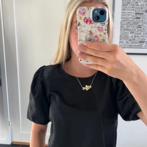 Svart kortärmad topp med puffärm - Säljer en svart klänning med puffiga korta ärmar och rund halsringning. Enkel och stilren design som passar perfekt till många tillfällen. Klänningen har en rak passform och är riktigt bekväm.