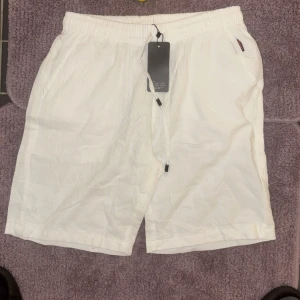 Vita linneshorts med snörning från Sport - Passar xs- M Fräscha vita shorts i linne från Sport med elastisk midja och snörning framtill. De har sidofickor och en bakficka för en chill look. Perfekta för varma dagar när du vill ha det bekvämt men ändå stilrent.