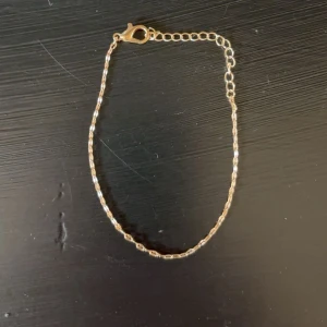 Tunt guldarmband med kedja - Snyggt och enkelt armband i guldton med tunn kedja och justerbar längd. Perfekt för dig som gillar minimalistiska smycken och vill ha något stilrent på handleden. Lätt att matcha med andra accessoarer. Mycket bra skick