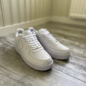 Airforce 1 Vita - Ett par mycket fina airforce 1 i vitt färg. Aldrig använda, finns även sko hållaren i skorna fortfarande, dock ingen box. Inga defekter, fick de som en present säljs för att de va för små!              Priset kan diskuteras!!!