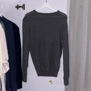 Mörkgrå stickad tröja Pier One - Snygg mörkgrå stickad tröja från Pier One med rund halsringning och långa ärmar. Enkel och stilren design som passar perfekt till jeans eller chinos. Mjuk och skön känsla tack vare det stickade materialet. 100% bomull!