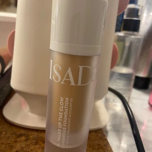 IsaDora Wake Up The Glow Foundation 3N - IsaDora Wake Up The Glow Luminous Foundation i nyansen 3N. Ger en naturlig glow med medium täckning. Innehåller vitamin E, hyaluronsyra och SPF 50. Kommer i en frostad glasflaska med vit pump och lock.