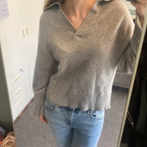 Grå stickad tröja med krage - Säljer en grå stickad tröja med bred krage och v-ringning. Skriv för mer detaljer 