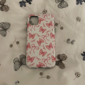 Vit mobilskal med rosa rosetter - Sött mobilskal i vitt med rosa rosett-mönster över hela ytan. Perfekt accessoar för dig som vill ha en gullig och personlig touch på mobilen. Passar till de flesta outfits och är lätt att ta med sig överallt.