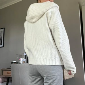 Vit stickad hoodie - Mysig vit stickad hoodie från BikBok i storlek XS. Använda fåtal gånger och i nytt skick! Nypris 500kr