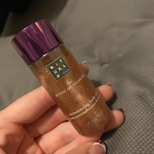 Rituals Shimmering Body Oil - Shimmering body oil från Rituals, The Ritual of Yozakura. Oljan har en guldig, skimrande finish och kommer i en genomskinlig plastflaska med lila lock. Perfekt för att ge huden en glowy look och extra lyster. Oanvänd!☺️