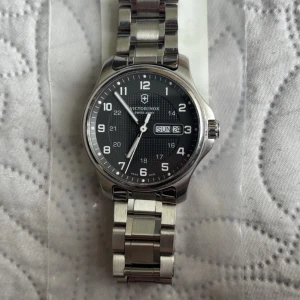 Victorinox swiss army 241590 - 🕰️ Victorinox Swiss Army 241590 – Tidlös schweizisk precision i rostfritt stål Upplev kraften i schweizisk ingenjörskonst med denna Victorinox Swiss Army 241590, en stilren och robust herrklocka som kombinerar funktionalitet, kvalitet och design i världsklass. Tillverkad i rostfritt stål och med en tidlös, sportig estetik är detta en klocka som passar både till vardags och vid mer formella tillfällen. Den är skapad för att tåla tuffa tag, men ser samtidigt elegant ut på handleden. OBS ingen box