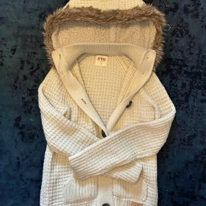 Stickad cardigan med päls luva - Säljer denna stickade cardigan med luva, otroligt fet samt bekväm och passar perfekt nu till hösten. Inga defekter och är i bra skick! Storlek S men passar XS också