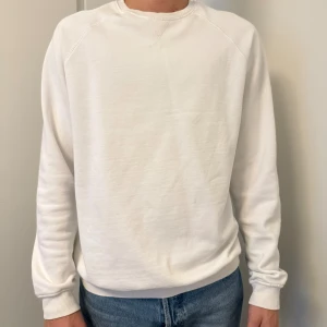 Vit sweatshirt från Pier One - En stilren vit sweatshirt från Pier One med rund halsringning och ribbade muddar. Tröjan är i mjuk bomull och har en klassisk passform med långa ärmar. Perfekt för en clean och enkel look.