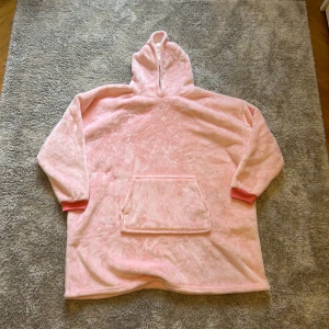 Oversized rosa fleece hoodie, SUPERMJUK - Supermysig oversized hoodie i ljusrosa fleece med stor känguruficka och huva. Utsidan är mjuk och fluffig, insidan har teddy-liknande struktur. Perfekt för chill dagar hemma eller när du vill vara extra cozy. Ingen etikett med oanvänd. Köpt i sinsay / strl L/XL