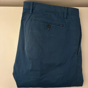  chinos från Polo Ralph Lauren - Snygga blå chinos från Polo Ralph Lauren. Slim fit-modell. Nypris cirka 2000kr. Skriv vid frågor eller funderingar.