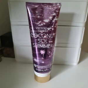 Victoria's Secret Coconut Sol Shimmer - Glittrig kroppslotion med kokosdoft från Victoria's Secret. Tuben är lila med skimrande detaljer och guldigt lock. Innehåller 236 ml och ger huden en solkysst glow med doft av kokos, mexikansk solros och havsbris. Perfekt för dig som vill ha extra lyster. Helt ny och oöppnad. Svarar ej på förhandlingar 