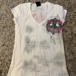 Vit t-shirt med tryck och v-ringning - Vit t-shirt från hard soda med v-ringning och tryck. 