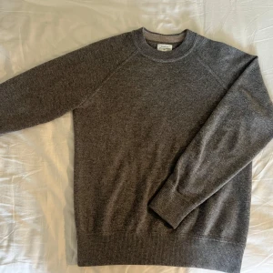 Grå stickad tröja från Hartford - Mysig grå stickad tröja från Hartford med rund halsringning och ribbade muddar. Perfekt för dig som gillar en enkel och stilren look. Perfekt nu till hösten. Den är gjord av 70 % ull och 30 % kashmir. Nypris ca 2300. Frakt betalar köparen 