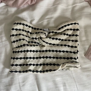 Randig bandeau tubtopp med knyt - Säljer en snygg bandeau tubtopp med svartvita ränder och knyt framtill i storlek s.