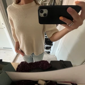 Beige/vit stickad tröja med kort ärm - Säljer nu denna trendiga supermjuka, oversized beige stickad tröja med korta ärmar från Gina Tricot. Perfekt att slänga på sig till jeans eller kjol en sommarkväll.