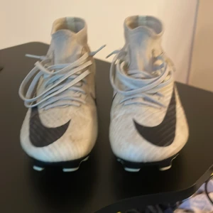 Nike Mercurial gul gröna fotbollsskor. Säljer dels för jag inte spelar fotboll och dom är för små. Storlek 40,5 - Säljer ett par Nike Mercurial fotbollsskor i grön gul med svarta detaljer och stora swoosh-loggor. Skorna har snörning, högre strumpliknande skaft och plastsula med dobbar för gräsplan. Perfekta för dig som vill sticka ut på planen.