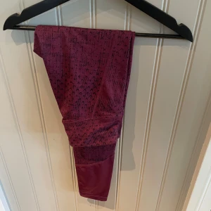 Mönstrade vinröda leggings från SOC XS - Snygga vinröda leggings från SOC i storlek XS. De har ett svart mönster upptill och är enfärgade nedtill. Tillverkade i ett stretchigt syntetmaterial som andas, perfekta för träning eller chill. Tight passform och bekväm midja.