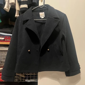 Mörkt blå skepparkavaj från Gina Tricot - Hej jag vill sälja min mörkt blå skepparkavaj från Gina Tricot med klassisk krage och dubbla knappar framtill. Jackan har två fickor och är i ett mjukt ull-liknande material. Perfekt för dig som vill ha en tidlös och snygg look.Jag köpte den för typ 3 månader sen vill sälja den för jag inte använder den längre.