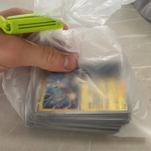 Pokémonkort - Blandad samling - Stor bunt Pokémonkort i en plastpåse, perfekt för dig som vill utöka din samling eller börja spela. Kortens skick och variation syns delvis genom påsen. Roligt för både samlare och spelare i alla åldrar!
