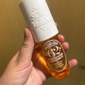 Sol de Janeiro Brazilian Crush 62 - Parfymmist med doft av pistage och saltad karamell från Sol de Janeiro. Flaskan är genomskinlig med orange vätska och har ett vitt, matt lock med präglad logga. Rymmer 90 ml och är perfekt att ta med i väskan för en fräsch, söt och tropisk känsla. Två sprut har använts. 