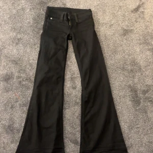 Svarta bootcut jeans från Cheap Monday - Svarta jeans från Cheap Monday med bootcut-modell och klassisk femficksdesign. Jeansen har en snygg utsvängd passform nertill och är tillverkade i ett stretchigt bomullsmaterial. Byxorna är lågmidjade och tyvärr för små för mig. 24/32. Helt oanvända 