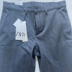 Grå rutiga kostymbyxor från Zara - Snygga grå kostymbyxor från Zara med diskret rutigt mönster. De är helt nya och aldrig använda. Prislapp sitter kvar. Pris kan diskuteras 