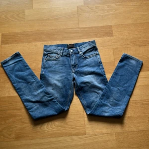 Blå slim fit jeans från J.Lindeberg - Snygga blå jeans från J.Lindeberg. Inte andvända då de va lite små. Nypris: 1200 kr storlek: W29 L32 