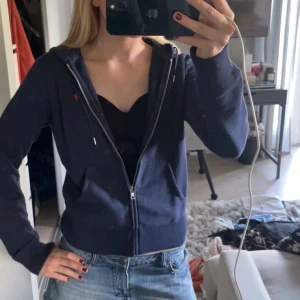 Mörkblå hoodie från Polo Ralph Lauren - Säljer en mörkblå hoodie från Polo Ralph Lauren med dragkedja och huva. Så skön och mysig.