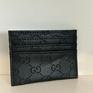 Svart kortfodral  - Säljer ett snyggt svart kortfodral. Perfekt för att hålla koll på dina kort och cash på ett snyggt sätt. Slimmad design som lätt får plats i fickan.