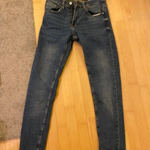 Blå jeans från Zara - Säljer ett par blå skinny jeans från Zara i klassisk tvätt. Jeansen har fem fickor, smal passform och normal midja. Materialet är mjukt och stretchigt för en bekväm känsla. Perfekta för dig som gillar en clean och enkel look. Pris kan diskuteras!