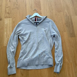 Ljusgrå half zip tröja Tommy Hilfiger S - Ljusgrå långärmad tröja från Tommy Hilfiger i premium bomull strl S. Klassisk modell med half zip och liten logga på bröstet. Ribbstickade muddar och krage med Hilfigers signaturrand på insidan. Perfekt för en clean och stilren look. Köpt för 749kr mitt pris 399kr.