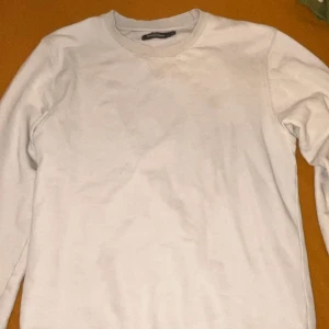 Vit basic sweatshirt långärmad - Enkel och stilren vit sweatshirt med rund halsringning och långa ärmar. Perfekt för dig som gillar en clean look. Mjuk och skön, passar till det mesta och är lätt att matcha med andra plagg.