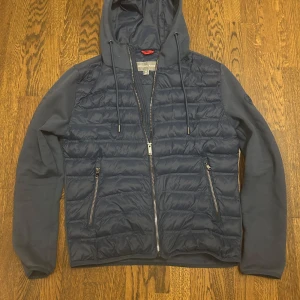 Mörkblå pufferjacka Michael Kors XS - Säljer en mörkblå pufferjacka från Michael Kors som är perfekt till hösten. Jackan är i storlek XS. Jackan har huva med snörning, quiltad framsida, dragkedja och två fickor med dragkedja. Jackan är i mycket bra skick! Ärmar och baksida är i mjukare material vilket gör jackan skönare. 