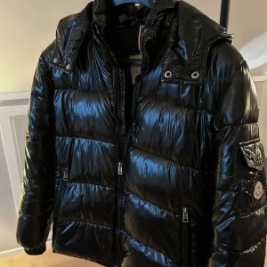 Moncler Maya  - Säljer en fet Moncler Maya perfekt till vintern. Glansig finish och legendarisk modell. Värmer bra kallare dagar. Har en liten skada i sömmen ovanför fickan därav priset. Skriv vid minsta lilla fråga. M men passar som S