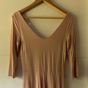 Smutsrosa långklänning från H&M - Säljer en elegant långklänning från H&M i en mjuk smutsrosa. Klänningen har djup v-ringning, trekvartsärm och ett flowy fall. Materialet är lent och stretchigt, vilket gör den superbekväm. Perfekt för dig som gillar stilrena och enkla looks. Använd en gång. Storleklapp avklippt men den är storlek S, bröst 85-88cm, längd 122cm.