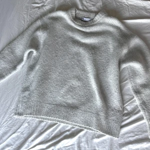 Vit stickad tröja från Zara - Mysig vit stickad tröja från Zara i storlek S. Tröjan har en klassisk rund halsringning och långa ärmar. Enkel och stilren design som funkar till det mesta.❤️