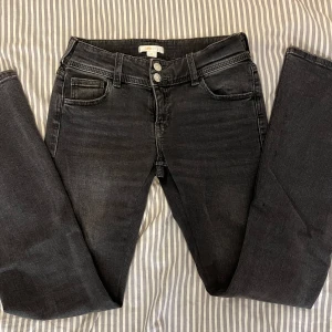 Svarta bootcut jeans - Snygga svarta bootcut jeans från Gina Tricot med dubbla knappar i midjan och klassiska fickor både fram och bak. Jeansen har en lätt tvättad look och är tillverkade i stretchig denim för skön passform. Sydda så att de är mer low waist samt insydda i midjan och benen. Storlek 158 men sitter bra på xs.