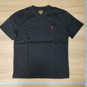 Polo Ralph Lauren T-shirt - Helt ny, svart t-shirt från Polo Ralph Lauren med röd broderad logga på bröstet. Modellen är custom slim fit med rund hals och korta ärmar. Tillverkad i mjuk bomull som känns skön mot huden. Perfekt för dig som gillar stilrena och klassiska plagg. Säljer för att den är för stor för mig.