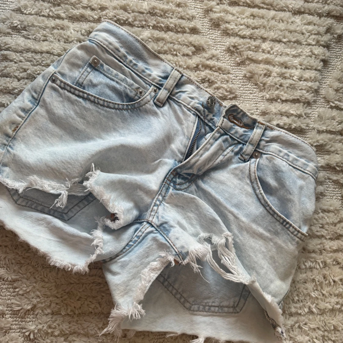 Ljusblå jeansshorts med fransig kant