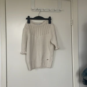 Vit stickad tröja med spetsmönster - Superfin vit stickad tröja med snyggt spetsmönster upptill. Tröjan har trekvartsärmar med volangkant och ribbade muddar. Perfekt för lager-på-lager och passar till allt! 🧶