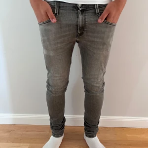 Replay grå anbass jeans herr - Säljer ett par grå skinny jeans från Replay. Jeansen har normal midja och smal passform hela vägen ner. Materialet är mjukt och stretchigt för extra komfort. Perfekta för dig som gillar en modern och stilren look.