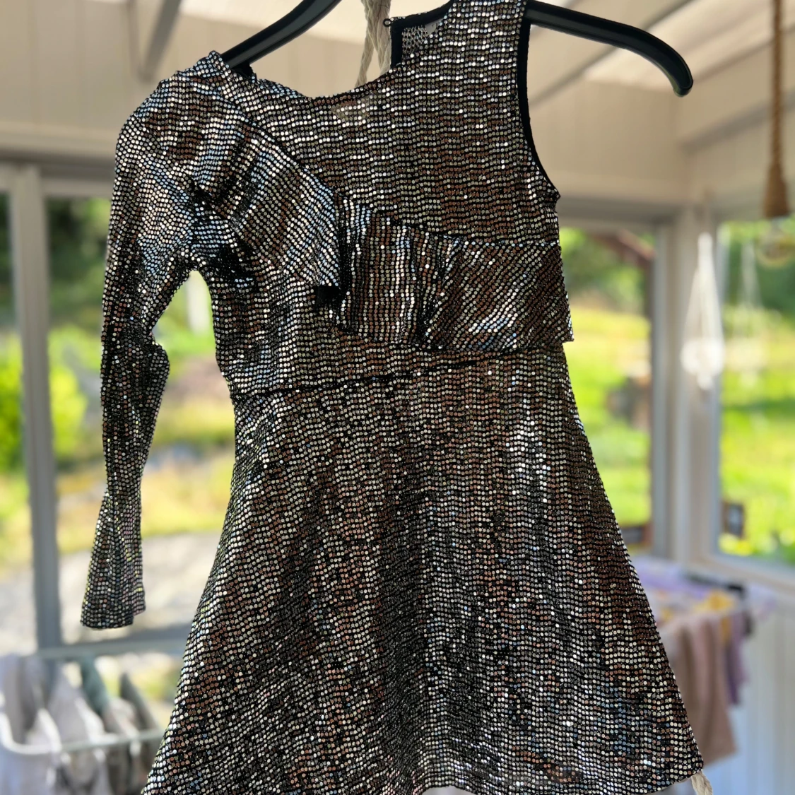 Glittrig silverklänning med volang